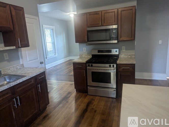 A kitchen with wooden cabinets and a stainless steel oven.