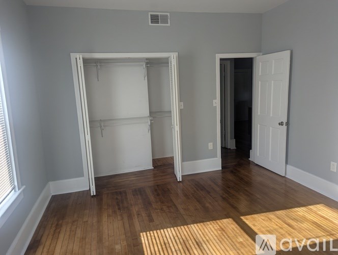 A room with a white door and a window with blinds.