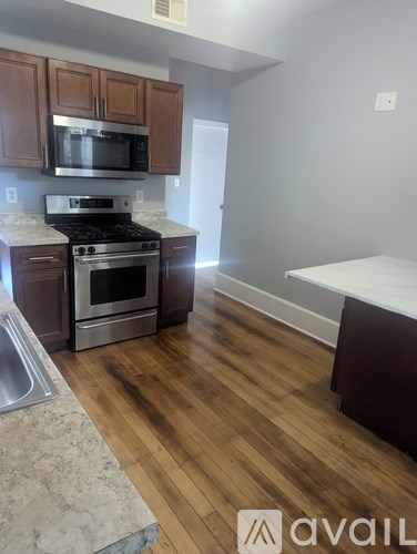 A kitchen with wooden cabinets and a stainless steel oven.