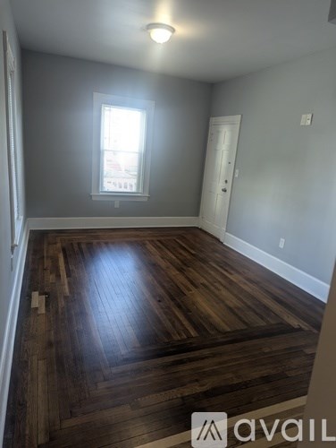 A room with wooden flooring and a window.
