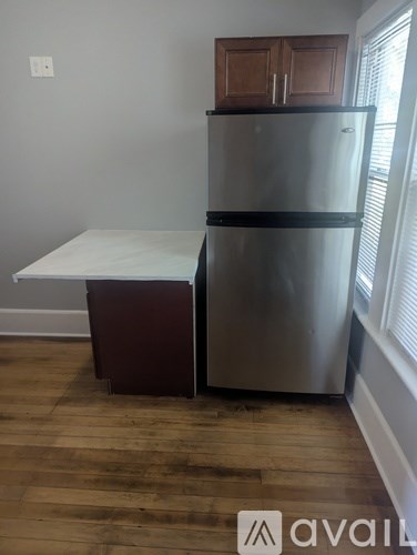 A kitchen with a refrigerator and a table.