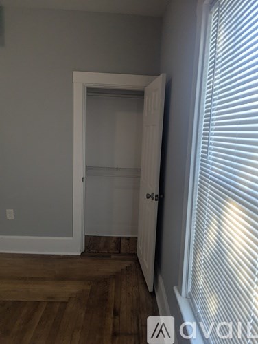 A room with a white door and a window with blinds.