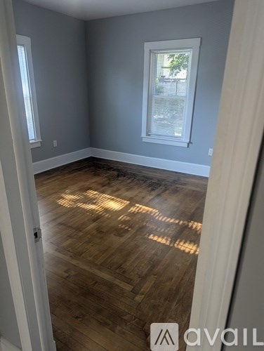 A room with wooden flooring and a window.
