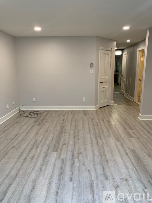 A room with wooden flooring and white walls.