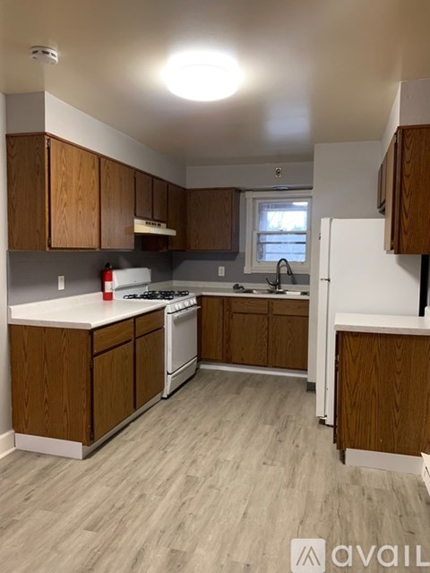 A kitchen with wooden cabinets and a white refrigerator.