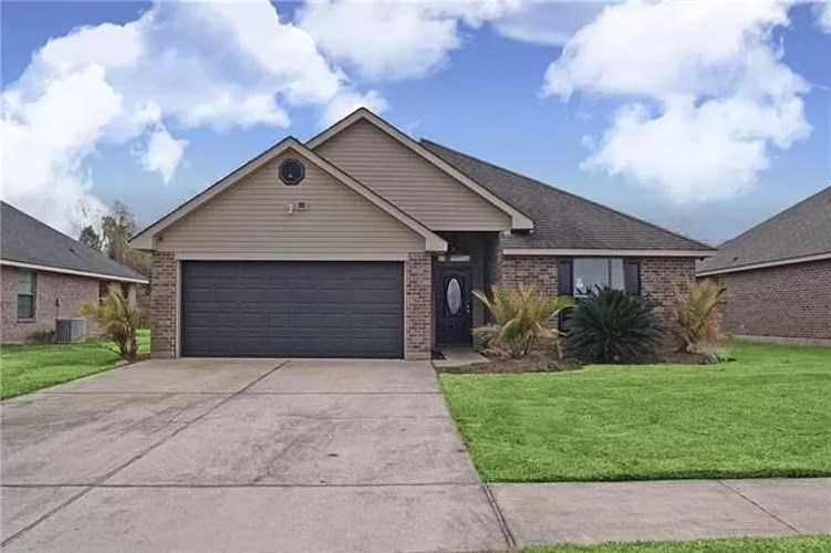 A house with a grey garage door and a black door.