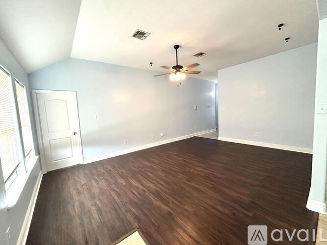 A room with wooden flooring and a ceiling fan.