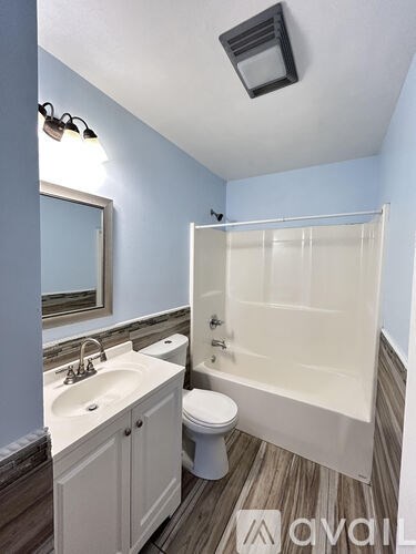 A bathroom with a white toilet, sink, and bathtub.