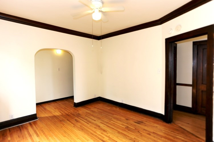A room with a wooden floor and a ceiling fan.