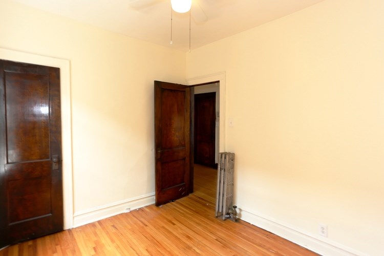 A room with a wooden door and a radiator on the floor.