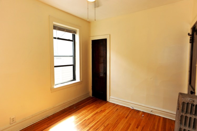 A room with a wooden floor and a window.