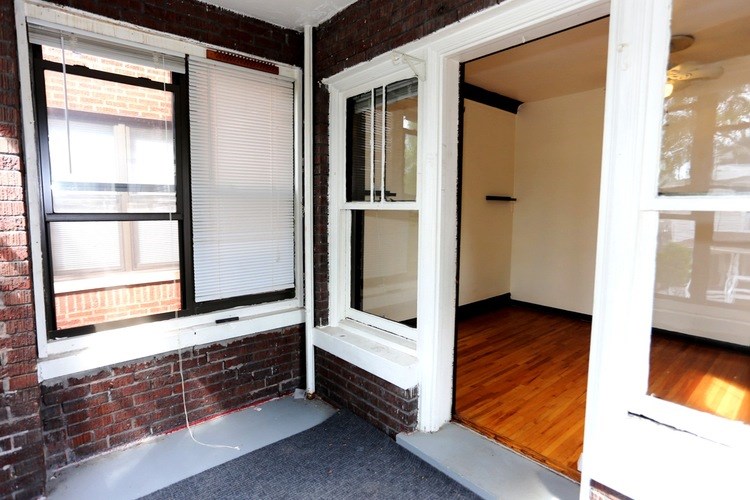 A room with a white door and a window with blinds.