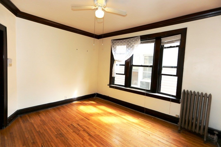 A room with a window and a radiator on the floor.