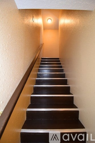 A staircase with a light on the wall at the top.