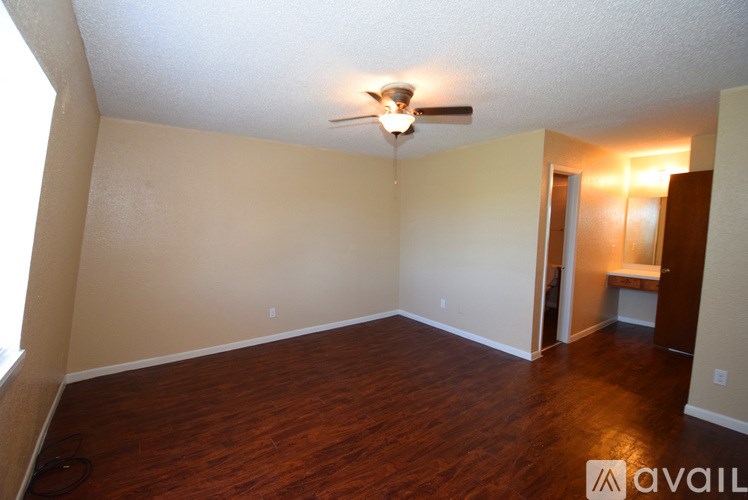A room with wooden floors and a ceiling fan.