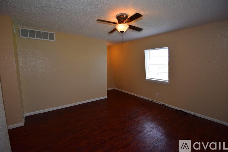 A room with a ceiling fan and a window.