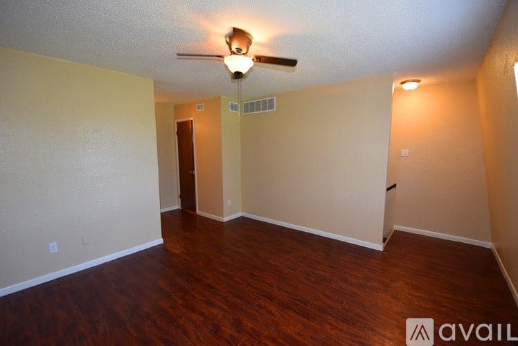 A room with a ceiling fan and hardwood flooring.