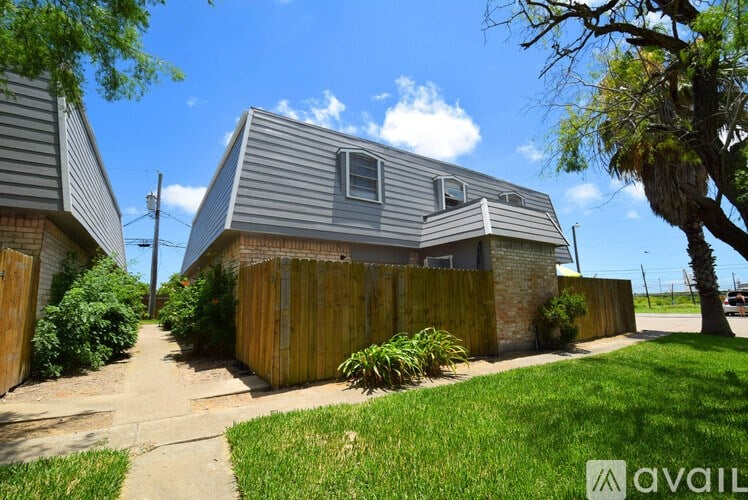 A house with a grey roof and a brown fence.