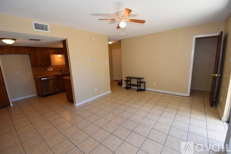 A living room with a tile floor and a ceiling fan.