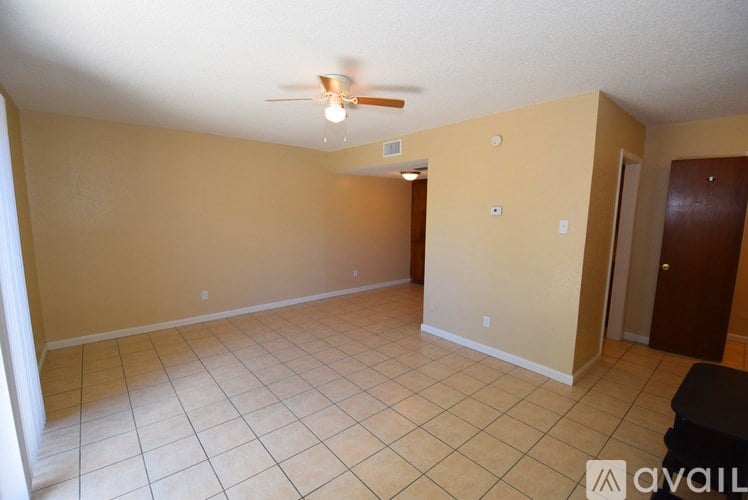 A room with a ceiling fan and tile flooring.