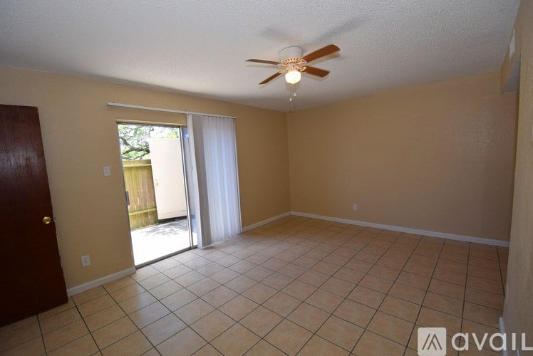 A room with a ceiling fan and tile flooring.