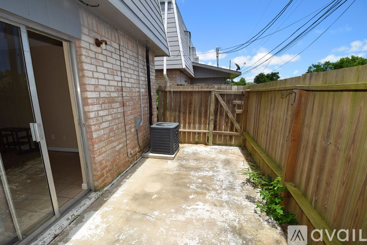 A backyard with a wooden fence and a brick wall.