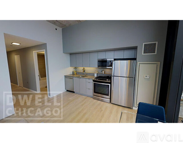 A kitchen with stainless steel appliances and a wooden floor.