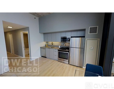 A kitchen with stainless steel appliances and a wooden floor.