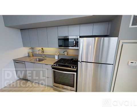 A kitchen with a stove, refrigerator, and microwave.