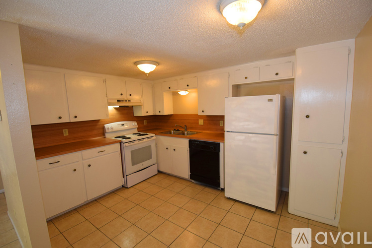 A kitchen with white appliances and cabinets.