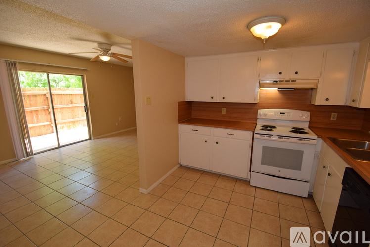 A kitchen with white cabinets and a stove top oven.