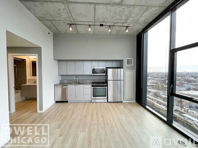 A modern kitchen with stainless steel appliances and a view of the city.