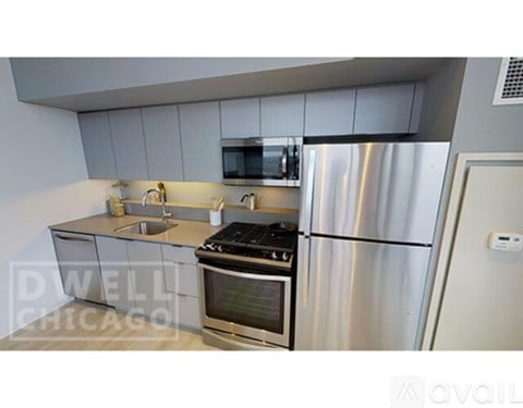 A kitchen with a stove, refrigerator, and microwave.