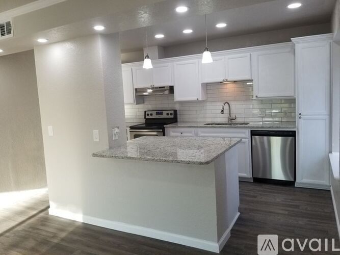 A kitchen with a granite countertop and white cabinets.