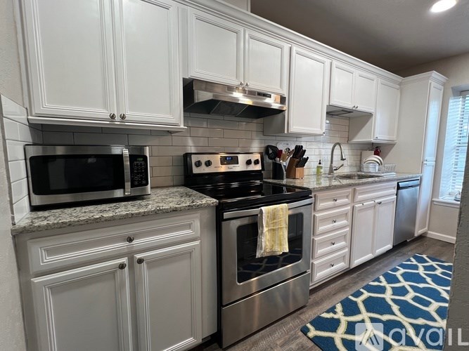A white bathroom with a toilet, sink, and bathtub.