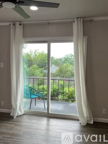 A room with a sliding glass door leading to a balcony.