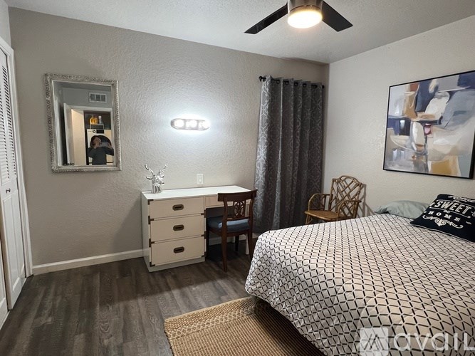 A bathroom with a white toilet, a sink, and a shower with a blue curtain.