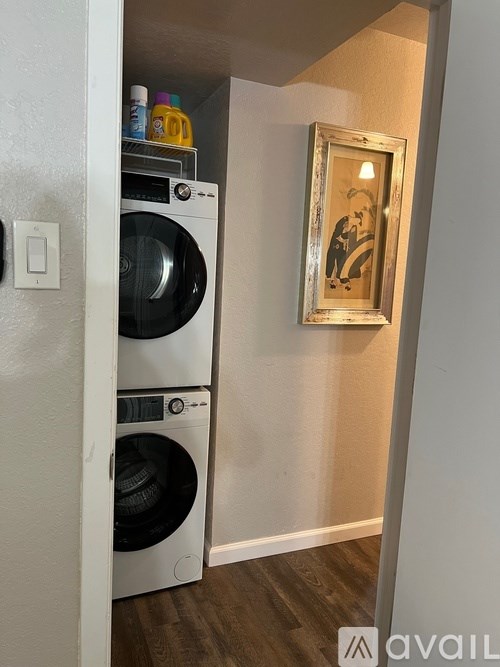 A washing machine is in the doorway of a room.