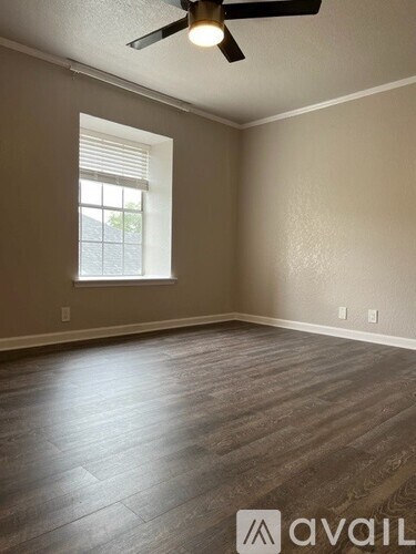 A room with a ceiling fan and a window.