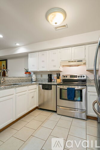 A kitchen with white cabinets and a stainless steel oven.
