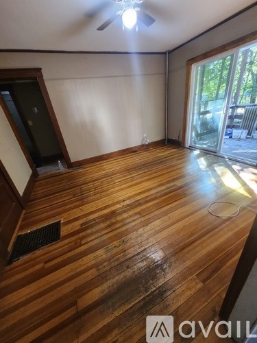 A room with wooden flooring and a ceiling fan.