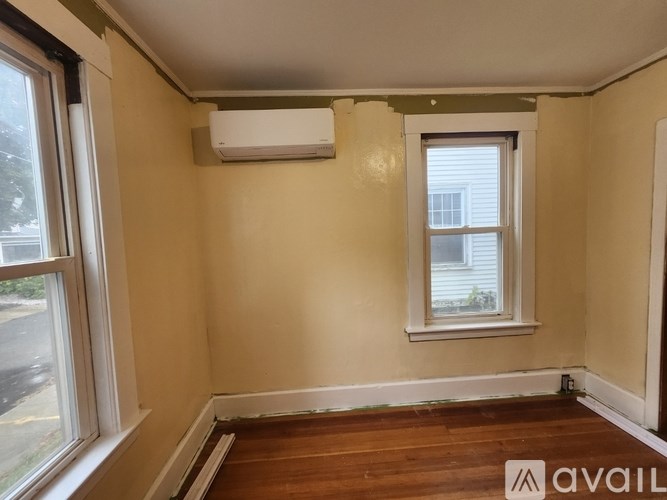 A room with a window and a wall-mounted air conditioner.