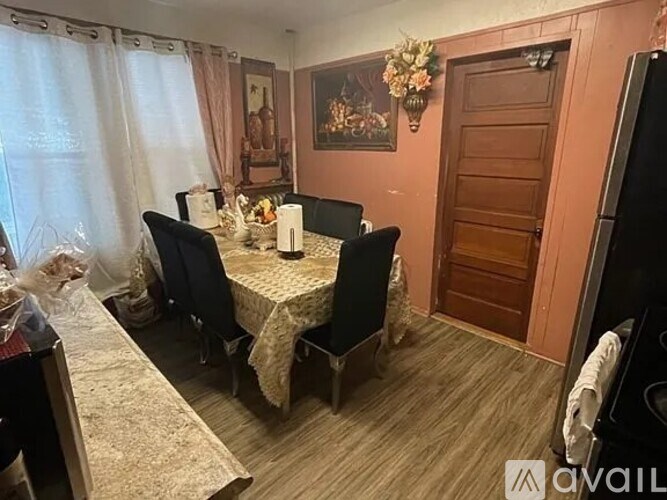 A dining room with a table set for two and a chandelier.