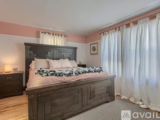 A bedroom with a large bed and a wooden headboard.