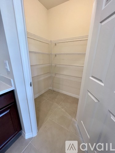 A white closet with shelves and a white door.