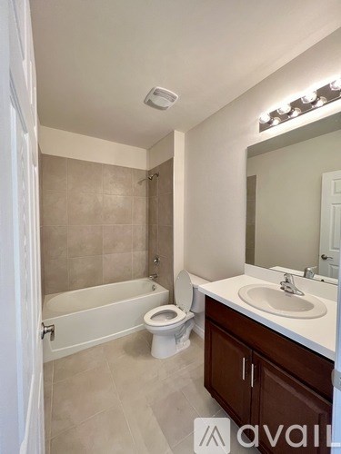 A bathroom with a toilet, sink, and bathtub.