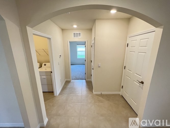 A hallway with a white door and a window.