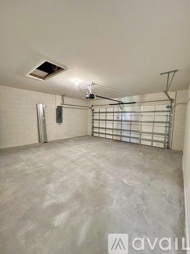 A spacious room with a metal gate and a vent on the ceiling.