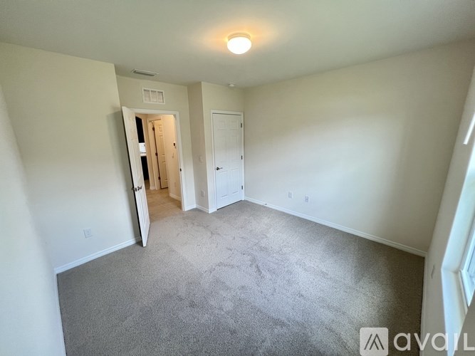 A room with a carpeted floor and a doorway leading to another room.
