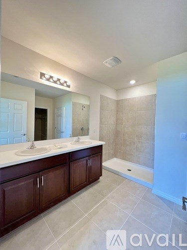 A bathroom with a large mirror and a walk-in shower.